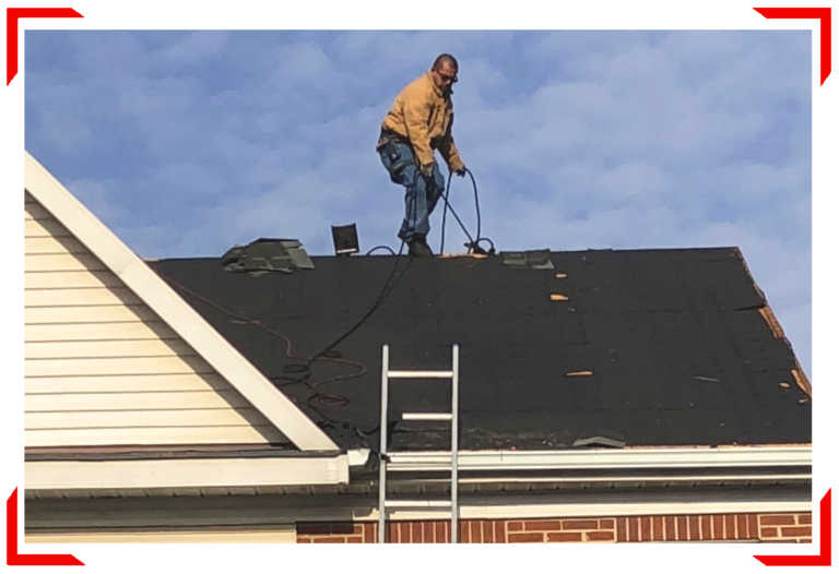 Man on top of roof repairing with cords and ladder